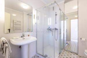 a white bathroom with a sink and a shower at Los Reales 8B in Estepona