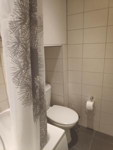 a bathroom with a toilet and a plant on the shower curtain at Majaka Apartment in Tallinn