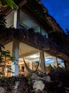 ein Haus mit einer Hängematte davor in der Unterkunft Casa AHAU in San Marcos La Laguna