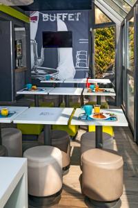 a dining area with tables and stools in a restaurant at ibis budget Antony Massy rénové 2024 in Antony
