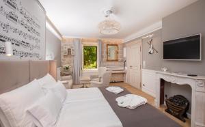 a bedroom with a white bed and a fireplace at Heritage Villa Nobile in Dubrovnik