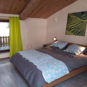 1 dormitorio con 1 cama con cortina verde en Les deux arches, en Caunes-Minervois