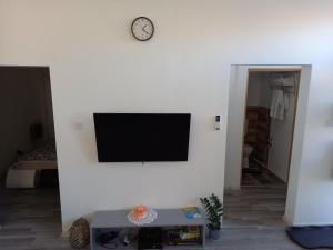 sala de estar con TV en una pared blanca en TITI House, en Bakonykoppány