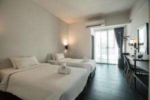 清邁的住宿－iWualai Hotel，酒店客房配有两张床和一张书桌