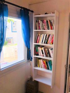 a book shelf filled with books next to a window at Denizati Pension in Bodrum City