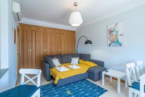 a living room with a couch with a yellow blanket at Rotunda da Marina in Portimão