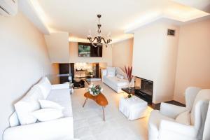 a living room with white furniture and a fireplace at Ninos Luxury Apartment in Corfu Town