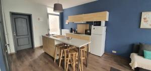 a kitchen with a white refrigerator and a counter with stools at LFA Charmante maison de ville in Flémalle-Grande
