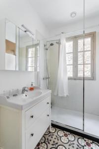 y baño blanco con lavabo y ducha. en Dame de Coeur - Appartement spacieux en plein centre historique, en Rennes