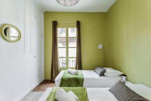 a bedroom with two beds and a window at Dame de Coeur - Appartement spacieux en plein centre historique in Rennes