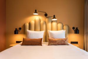 ein Schlafzimmer mit einem großen weißen Bett mit zwei Kissen in der Unterkunft Hotel Zeeuws Licht I Kloeg Collection in Dishoek