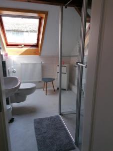 a bathroom with a sink and a toilet and a window at FW Mittschiffs, 1 Obergeschoss, Petershof-Lehbek in Gelting