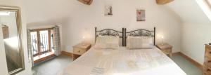 una camera da letto con un letto grande con due comodini di Lupin Cottage at Boningale Manor a Wolverhampton