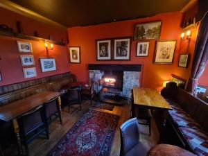 un bar con chimenea en una habitación con paredes de color naranja en The New Inn, en Skipton