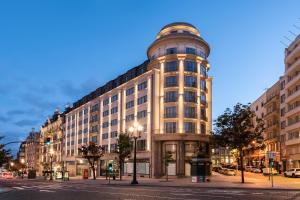 a large building on a city street at night at Eurostars Aliados in Porto