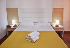 a bed with two towels on a yellow blanket at Favignana Casa Vacanza Orsola in Favignana