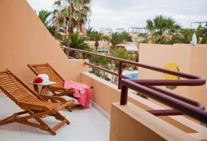 a balcony with two chairs and a table at Apartamento Kalma by Vacanzy Collection in Corralejo