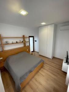 1 dormitorio con 1 cama y suelo de madera en Gjiri Lalzit Apartment en Durrës