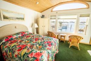 a bedroom with a bed with a colorful bedspread at The Ocracoke Harbor Inn in Ocracoke