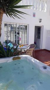 una bañera de hidromasaje en un patio con mesa y sillas en Apartamento Perseo en Corralejo