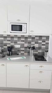uma cozinha com um lavatório e um micro-ondas em Apartamento Perseo em Corralejo
