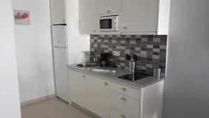 a small kitchen with a sink and a microwave at Apartamento Perseo in Corralejo