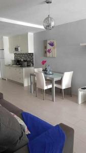 a living room with a table and chairs and a kitchen at Apartamento Perseo in Corralejo