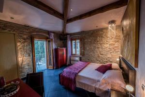 a bedroom with a bed and a stone wall at Strada Giulia 16 in Bolgheri