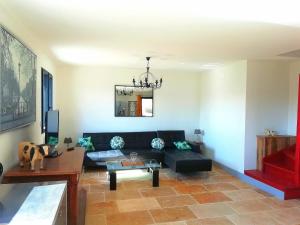 a living room with a black couch and a table at Gite les carriaux in Le Fied