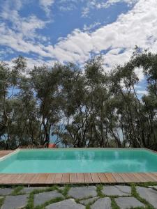 a swimming pool with a wooden deck and trees at Cà del Mago in Lerici