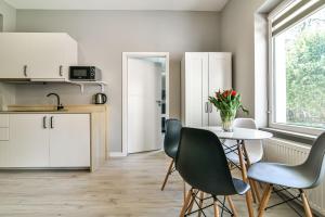 a kitchen with a table and chairs in it at LTC Apartments Haffnera in Sopot