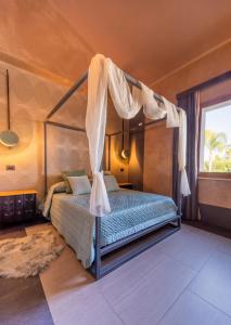 a bedroom with a bed with a canopy at Aqua Venere Pool & Suites in Marsala