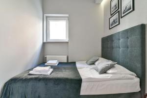 ein Schlafzimmer mit einem Bett mit zwei Handtüchern darauf in der Unterkunft LTC Apartments Haffnera in Sopot