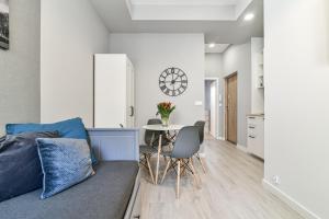 eine Küche und ein Wohnzimmer mit einem Sofa und einem Tisch in der Unterkunft LTC Apartments Haffnera in Sopot