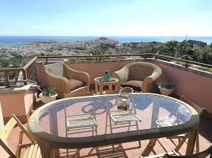 a glass table and chairs on a balcony at Villa Arenella in Vieste