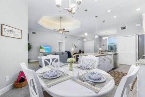 een keuken en eetkamer met een witte tafel en stoelen bij Newly built home with heated pool, close to many amenities - Villa Sandle in Cape Coral