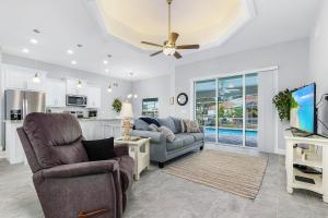 een woonkamer met een bank en een tv bij Newly built home with heated pool, close to many amenities - Villa Sandle in Cape Coral