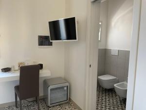 baño con aseo y TV en la pared en Casa Birra Salento, en Leverano