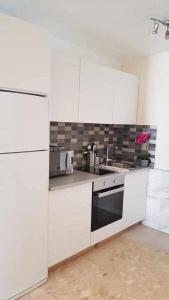 a white kitchen with a sink and a stove at Apartamento Ocean in Corralejo