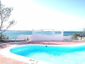 a swimming pool in front of a house at Apartamento Coral Bay by Vacanzy Collection in Corralejo