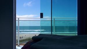 a room with a view of a beach and the ocean at Hotel Pousada Agua Marinha in Guaratuba