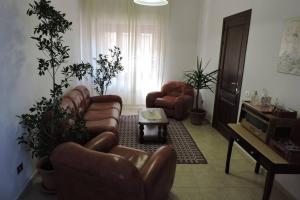 sala de estar con sillas de cuero y mesa en CASA FIGUS Via Roma 20 Narbolia, en Narbolia