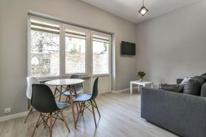ein Wohnzimmer mit einem Tisch, Stühlen und einem Sofa in der Unterkunft LTC Apartments Haffnera in Sopot