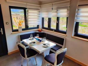 a dining room with a table and chairs and windows at Holiday home Pipila in Dol