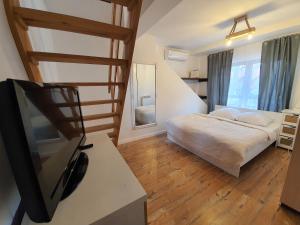 a bedroom with a bed and a flat screen tv at Pensjonat Amber in Pobierowo