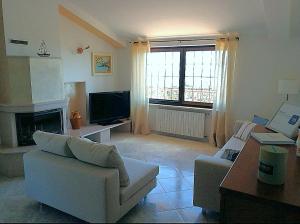 a living room with a white couch and a television at Villa Arenella in Vieste
