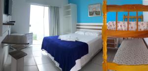 Hotel Pousada Agua Marinha في غواراتوبا: غرفة نوم مع سرير بطابقين وجدار ازرق