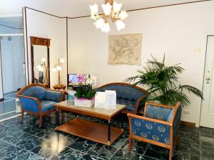 a living room with chairs and a table and a table sidx sidx at Hotel Villa Margherita in Limone sul Garda