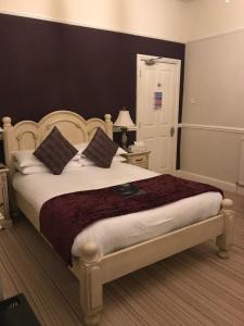 a bedroom with a large bed with white sheets and pillows at Lauriston & Lawton Court Hotel in Llandudno