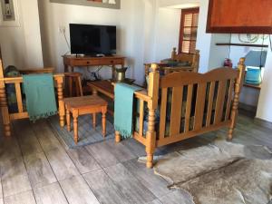 a living room with wooden furniture and a tv at Fisherman's Cottage in Hondeklipbaai